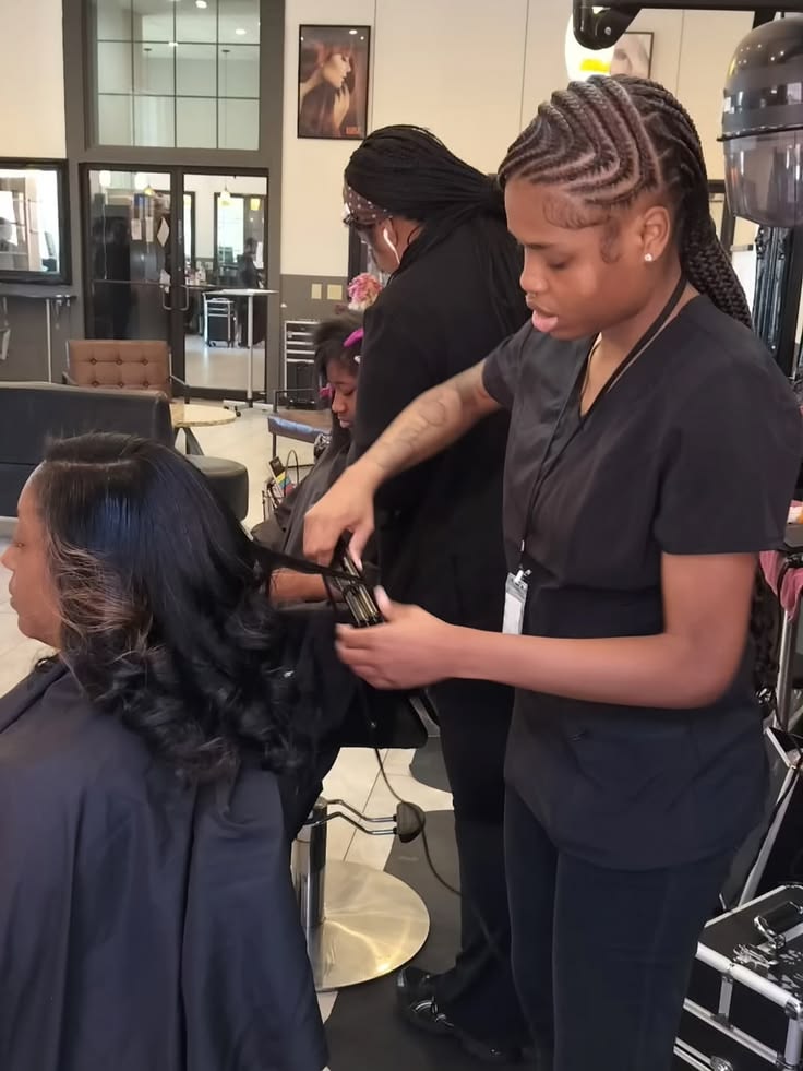 Hairstylist braiding an African woman's hair
