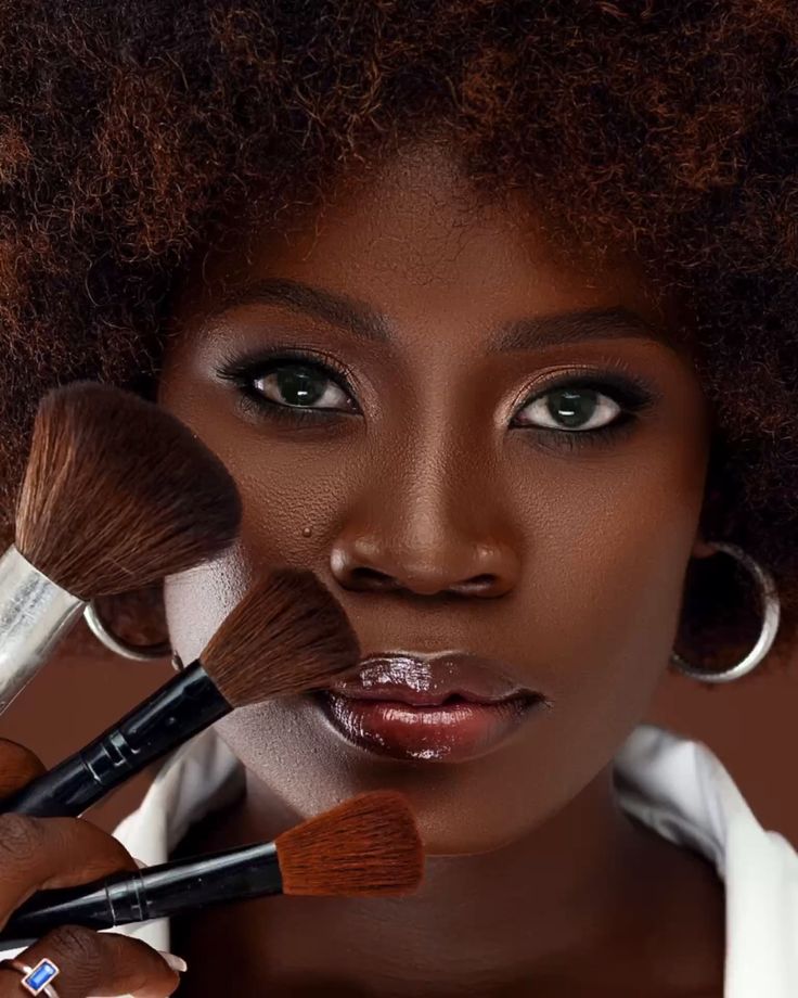 Makeup artist applying makeup to a Black woman